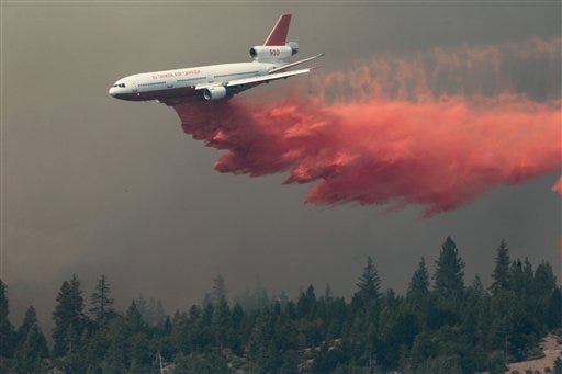 A DC-10 drops fire retardant on the Ponderosa Fire Monday Aug. 20, 2012, near Paynes Creek, Calif. Nearly 1,900 firefighters were battling the Ponderosa Fire in rugged, densely forested terrain as it threatened 3,500 homes in the towns of Manton, Shingletown and Viola, about 170 miles north of Sacramento. (AP Photo/The Record Searchlight, Andreas Fuhrmann)