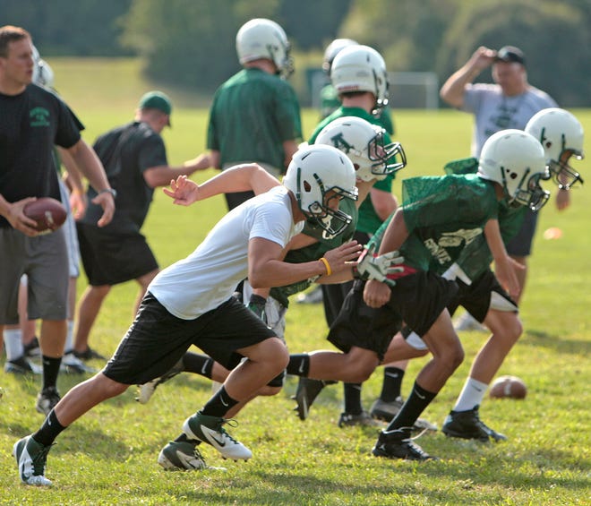 The Abington High football team runs through drills during the Green Wave's practice on Tuesday.