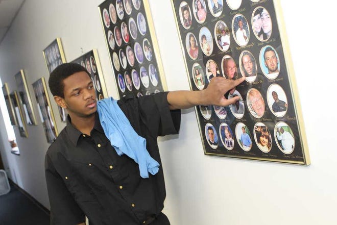 Hozae Milton points to a photo of his brother in the Compassionate Families office in Jacksonville. His brother was a murder victim, and the nonprofit is helping Milton with educational and employment needs. The agency is among those facing cuts in the legal system.