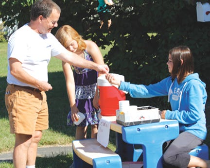 Dennis Akers of the Sault visited this Easterday Avenue lemonade stand operated by Britney Young, 11, and Destini Perry, 12, on Wednesday. The young entrepreneurs were reportedly trying to earn money in anticipation of the Chippewa County Fair.