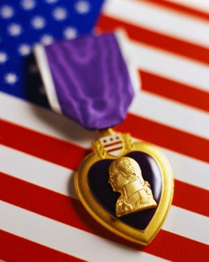 ca. 2001 --- Purple Heart on American Flag --- Image by © Royalty-Free/Corbis