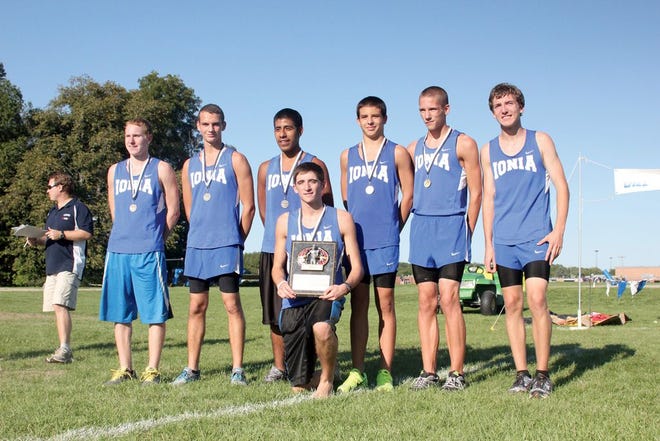 The Ionia boys cross country team poses with the Lakewood Invitational Championship trophy Wednesday afternoon. The varsity runners in the event include, from left, individual champion Brice Brown, Dillon Braun, Jorge Cardenas, Brandon Winter, Jordan     Zamarron, Marshel Rademacher and Peter Pelon.