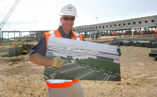 Bret Spangler, site director, shows the artist's rendering of the new Topeka Mars Chocolate plant and the location of the entrance, which is right behind where he is standing.