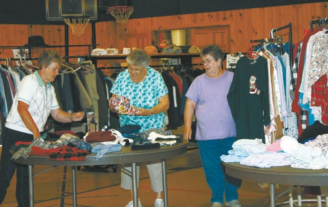 Clothing exchange volunteers Diane Travis,left, Sharon Cooper, center, who is the current chairperson of the program and Mary Streitmatter take time to straighten out clothes Thursday. Today is the last day of the exchange.