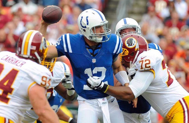 Indianapolis Colts quarterback Andrew Luck throws a pass as he is hit by Washington Redskins defensive end Stephen Bowen during the first half of an NFL preseason football game Saturday, Aug. 25, 2012, in Landover, Md. (AP Photo/Richard Lipski)