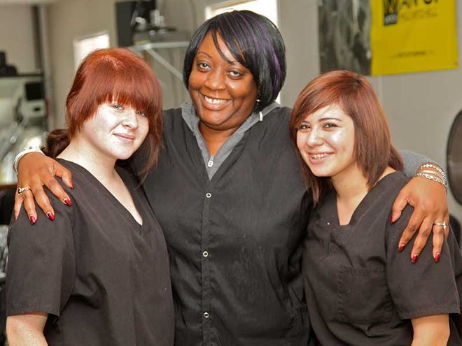 Instructor Adrienne Harvey, center, poses with two of her students, Jenna Cole, left, and Swazibelle Brenes, who started the cosmetology program while attending Flagler Palm Coast High School.