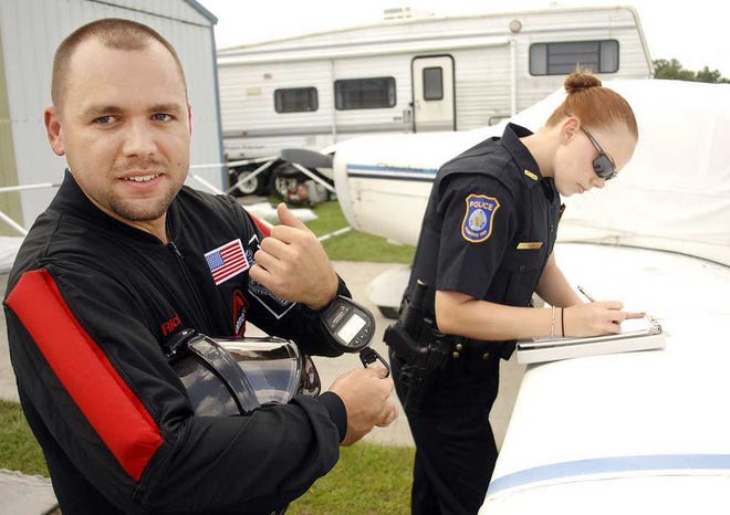 Photos by Terry.Dickson@jacksonville.com  Richard Turner waits while St. Marys police officer Amanda Graw writes him a trespass warning for skydiving at St. Marys Airport on Saturday with The Jumping Place.