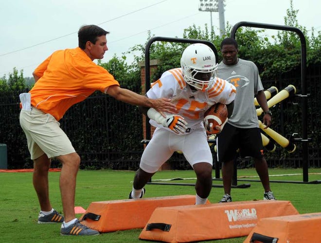 Tennessee coach Derek Dooley works with tailback Marlin Lane during the first day of fall practice Friday, Aug. 3, 2012 in Knoxville, Tenn. The Vols open the season Aug. 31 in the Chick-fil-A Kickoff Game with North Carolina State in Atlanta. (AP Photo, Adam Brimer/Knoxville News Sentinel)