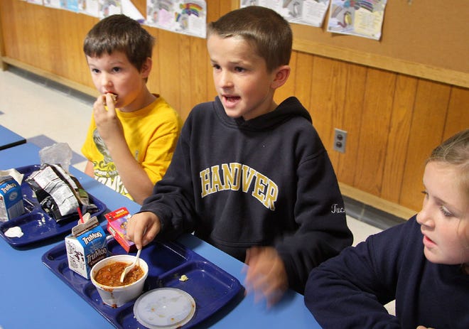 Fourth-graders Kevin Slowey, Tucker Leslie and Meghan Collett talk about their lunches at the Cedar Elementary School in Hanover in October 2011.