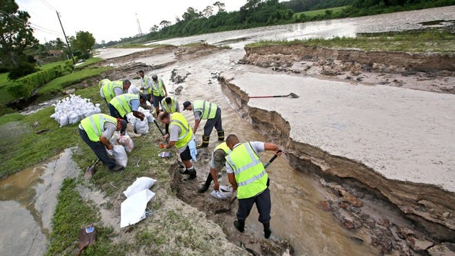 Indian Trail Improvement District workers fill sand bags Tuesday on 40th Street North in The Acreage where it is washed out just east of Coconut Blvd. in the aftermath of Tropical Storm Isaac.