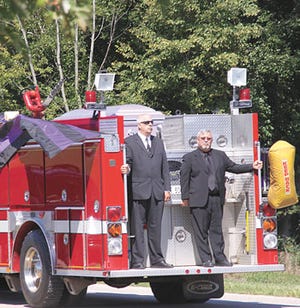 St. Joseph County 911 Director Jon Uribe, right, and 911 telecommunicator Doug Kuhlman stand watch over the body of fellow dispatcher Lois Devlin while her body was taken to her final 
resting spot Tuesday.
