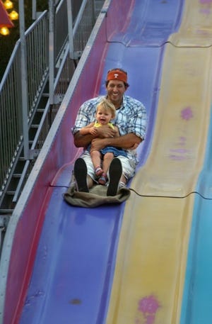 Christopher Cianfero (of Evesham) and daughter Tessa Cianfero (age 20 months), ride the "Fun Slide", on the last day of the St. Joan of Arc carnival, Saturday night in Evesham.