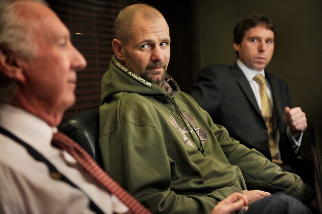 Kenny Meinders, center, listens to responses from his attorneys Dan Cusack, left, and Shaun Cusack at a news conference Friday at Dan Cusack's law office. Meinders was indicted Thursday by a Woodford County grand jury for his involvement in an August incident that left him hospitalized.
