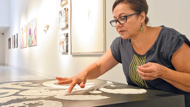Giannina Coppiano Dwin touches up her work using sugar crystals on a wood platform Tuesday for an exhibit at the Cultural Council of Palm Beach County in Lake Worth. Dwin was in the first graduating class of Florida Atlantic University’s master of fine arts program.