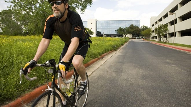 John Jolly rides to his South Austin home from his office, in background, at the Texas Commission on Environmental Quality near I-35 and Yeager Lane on Wednesday April 14, 2010.