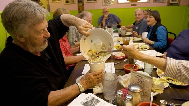 Dar Richardson gets some help bagging his leftovers Thursday at El Azteca Restaurant. The East Seventh Street eatery reports seeing a jump in business of 75 percent or more during SXSW.