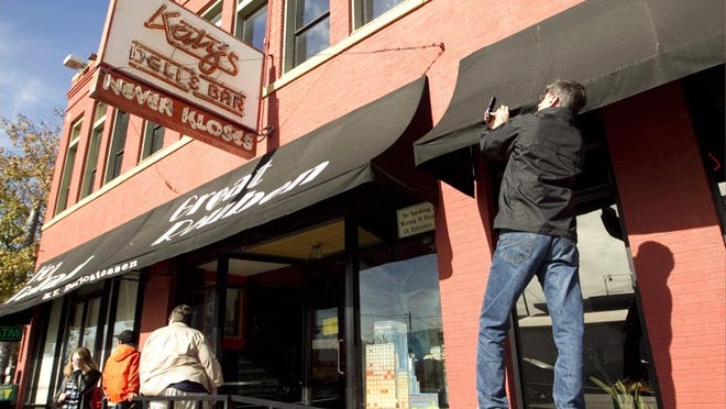 Robert Hargrave snaps a shot of the Katz's Deli sign on Sunday after the 24-hour restaurant called it a day. 'It's an Austin institution just like the Armadillo World Headquarters, Stevie Ray Vaughan and Clifford Antone. It will be missed,' says Hargrave, who says he's been eating at Katz's since 1982.