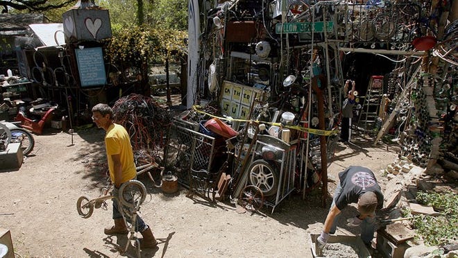 Cathedral of Junk owner Vince Hannemann, left, started creating the attraction behind his South Austin house in 1988. Some of the junk is being moved to solve an easement problem.