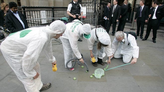 Costumed protesters perform a 'cleanup' Tuesday outside the National Portrait Gallery in London, where the BP Portrait Award ceremony is held.