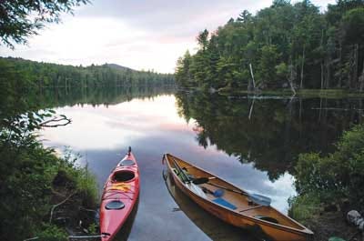 AP Photo/Mary Esch - A kayak and solo canoe rest at a campsite on East Pine Pond in the Saranac Lakes Wild Forest at Saranac Lake, N.Y. A new guidebook, “Adirondack Paddling: 60 Great Flatwater Adventures,” is due out this year.