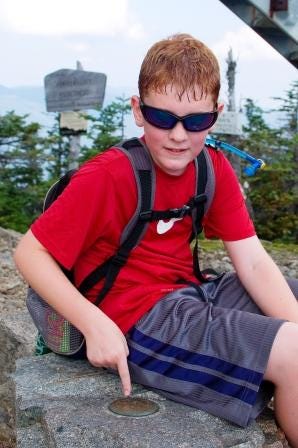 Ten-year-old Henry Wheeler of Norwell capped a three-year quest on Friday, Aug. 31, 2012, when he reached the 4,265-foot summit of Bondcliff in New Hampshire’s Pemigewasset Wilderness. It was the last of the 48 highest peaks in the White Mountains he has climbed. Here he is at the summit marker atop Carrigain.
