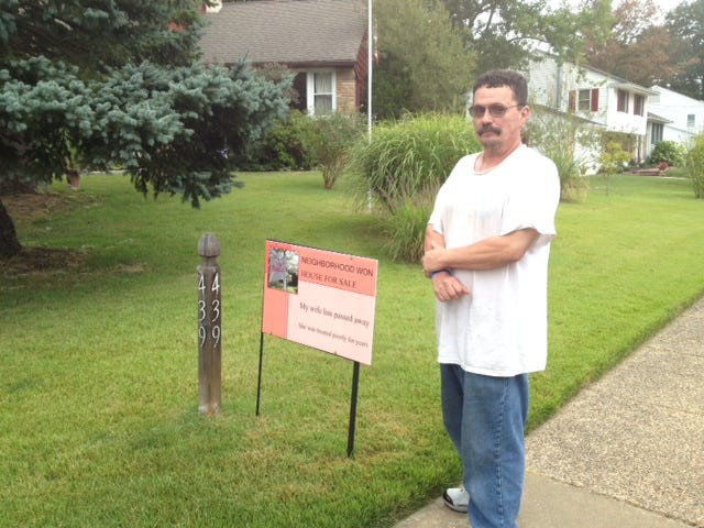 Bob Sherker stands with a sign criticizing his neighbors. in Eastampton, N.J.