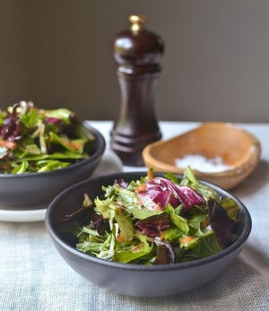 A salad of mixed greens tossed with a flavorful vinaigrette is the perfect accompaniment to many different meals.