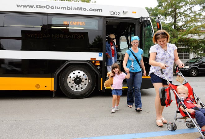 Jennifer Schnell and her daughter, Sophie, follow friends Anne Griffin and her son, Marcus, off a Columbia bus.