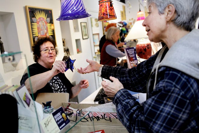 Sandy Litecky of Bluestem Missouri Crafts, left, helps customer Mar Doering make a purchase Nov. 5, 2011.