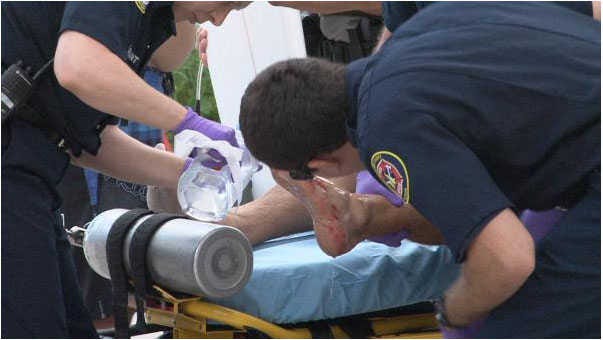 St. Johns County Fire Rescue paramedics treat a man who was bitten on the foot while surfing near A Street in St. Augustine Beach Thursday morning.