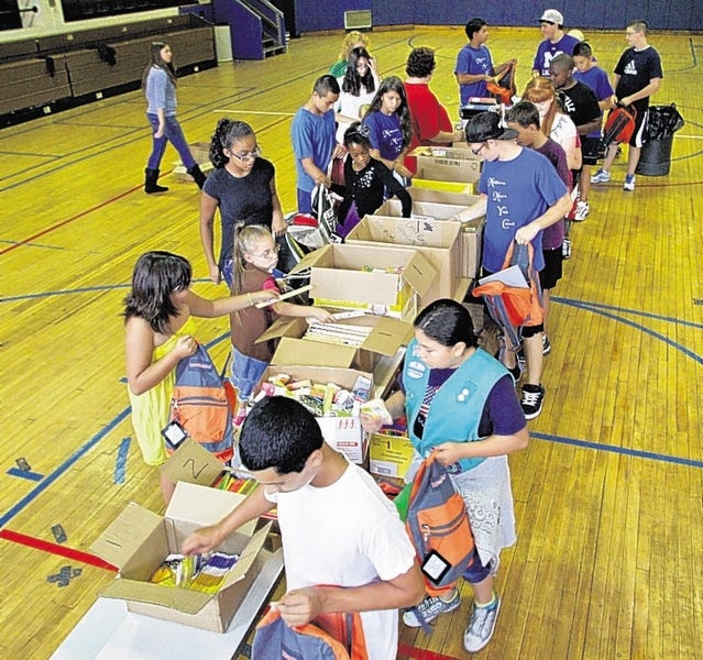 Members of the Middletown Mayor's Youth Council and Girl Scouts from Troops 239 and 529 of Middletown fill backpacks with donated school supplies Wednesday in the gymnasium at Middletown Parks and Recreation. A total of 350 backpacks were filled and then delivered to seven Middletown schools.