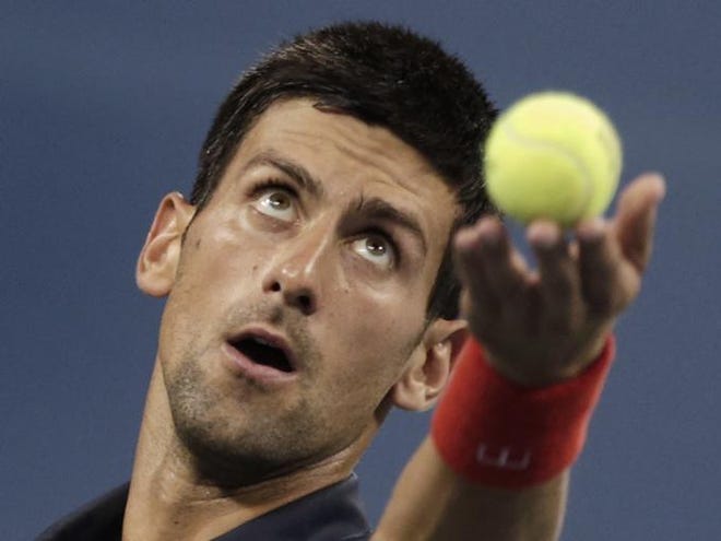 Novak Djokovic, of Serbia, tosses the ball on a serve to Juan Martin del Potro, of Argentina, in the quarterfinal round of play at the U.S. Open tennis tournament on Thursday, Sept. 6, 2012, in New York.