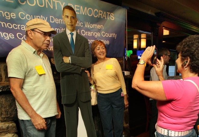 Joan Hutcher takes a photo of Millie and Horace Porter with a cardboard cutout of President Barack Obama at the Orange County Democrats' gathering at Rambler's Rest on Thursday in Monroe.