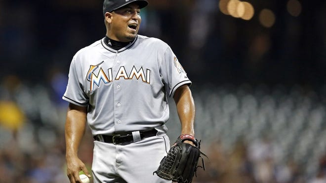 Miami Marlins' Carlos Zambrano yells to first baseman Greg Dobbs after Zambrano was credited with a throwing error against the Milwaukee Brewers during the fifth inning of a baseball game, Monday, July 2, 2012, in Milwaukee. (AP Photo/Tom Lynn)