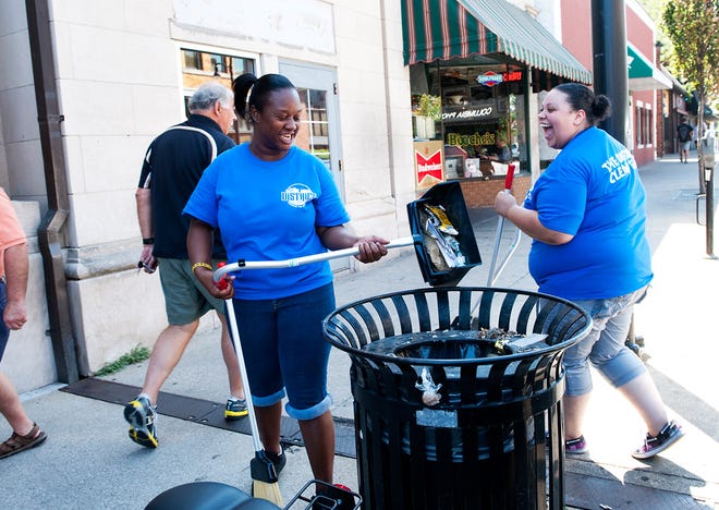 Douglass students Jyquintha Lambert, 18, left, and Donnesha Troy, 18, joke Friday while emptying trash into bins along Ninth Street. The Douglass High School students are interning with the Downtown Community Improvement District this semester to learn trade and service skills. Mark Anderson, who has worked with the downtown organization for more than 10 years, showed the students around on their first day.