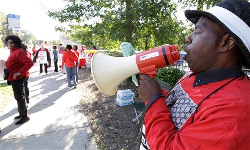 Michael Grant, a parent of a Chicago public school student, walks a picket line outside Shoop Elementary School in support of striking CPS teachers, Tuesday, Sept. 11, 2012. This is the second day of a strike in the nation's third-largest school district as negotiations by the two sides failed to reach an agreement Monday in a bitter contract dispute over evaluations and job security. (AP Photo/M. Spencer Green)