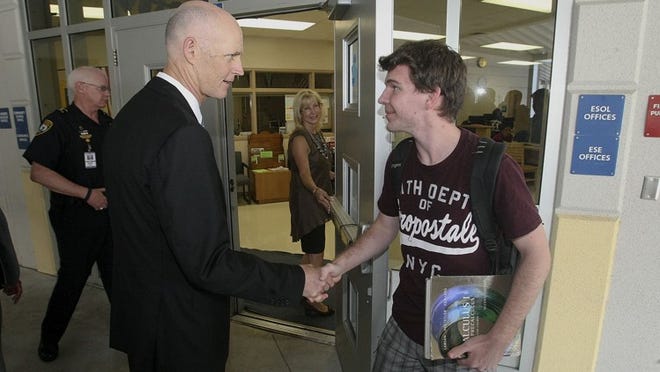 Gov. Rick Scott shakes hands with Ryan Tolder, a Boca Raton High School senior, just prior to the start of a 9/11 memorial ceremony in the school’s auditorium Tuesday.