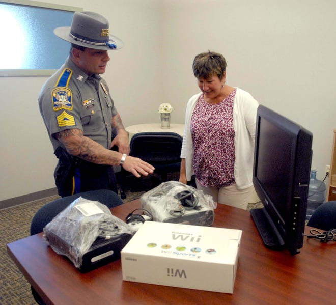 Master Sgt. Cliff Labbe, the executive officer at Troop D, talks with TEEG's executive director Donna Grant at TEEG. Master Sgt. Labbe brought over game consoles and a television that was confiscated from drug bust in the Windham County area.
