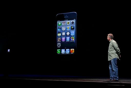 Phil Schiller, Apple's senior vice president of worldwide marketing, watches on stage the unveiling of the new iPhone 5 at an Apple event in San Francisco, Wednesday Sept. 12, 2012.