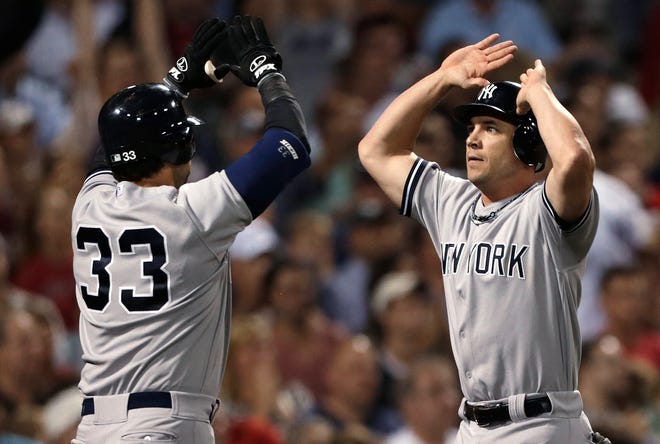New York's Steve Pearce (right) is congratulated by Nick Swisher after scoring on a single by Derek Jeter in the seventh inning of teh Yankees' 2-0 win over the Red Sox Thursday night.