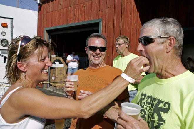 Teri Minnaert of Geneseo feeds a deep-fried turkey testicle to Richard Seys of Cole Valley as Ken Hull of Calona watches Saturday, Oct. 9, 2010, during the Turkey Testicle Festival in Byron.