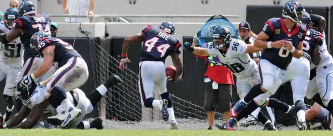 Texans running back Ben Tate runs through a hole in the line by the outstretched arm of Kyle Bosworth (56) for a 2-yard TD run in the third quarter Sunday at EverBank Field.