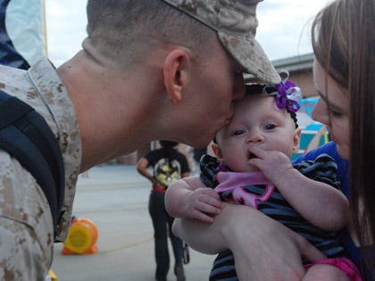 S.Sgt. Nathan Heilman, of Marine Unmanned Aerial Vehicle Squadron 2, plants a kiss on his four-month-old baby's head as his wife Amy holds her. Amerie Jane Heilman was born the day before Heilman left for Afghanistan.