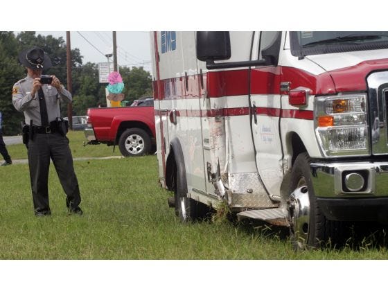 N.C. Highway Patrol Trooper J. S. Horton investigates an ambulance after it was involved in a wreck with a car on Polkville Road on Wednesday.