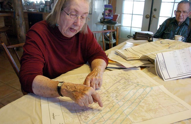 In her house south of Roundup, Mont., Ellen Pfister examines a map depicting 
the Bull Mountain Mine that reaches beneath her ranch, as husband Don Golder 
looks on.
ASSOCIATED PRESS ARCHIVE / APRIL 2012