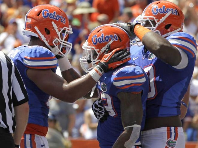 Florida running back Mike Gillislee, center, celebrates a 1-yard touchdown against Kentucky with tight end Clay Burton, left, and offensive linesman D.J. Humphries during the first half of an NCAA college football game Saturday, Sept. 22, 2012, in Gainesville. (ASSOCIATED PRESS)