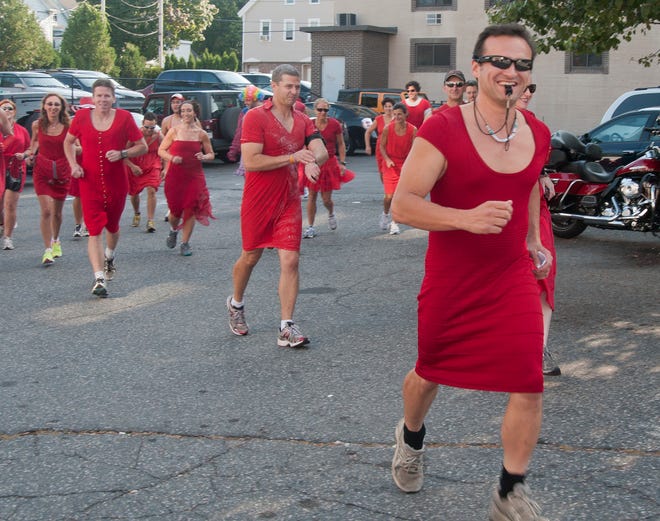 Joe LaValle of Northborough, blows his whistle starting the Red Dress Run, as his fellow Hash House Harriers runners follow. The group gathered at the Prospector Saloon in Marlborough for Saturdays run.