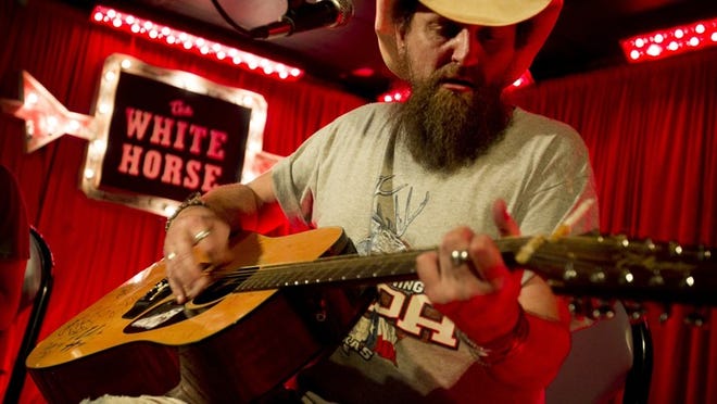 Robert Allan Caldwell performs at the White Horse. Popular Austin-based bands dot the club's schedule, with some claiming a regular night every week. Caption 4