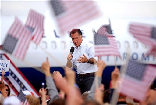 Flags wave as Republican presidential candidate, former Massachusetts Gov. Mitt Romney speaks at Pueblo Weisbrod Aircraft Museum in Pueblo, Colo., Monday, Sept. 24, 2012. (AP Photo/Bryan Oller)
