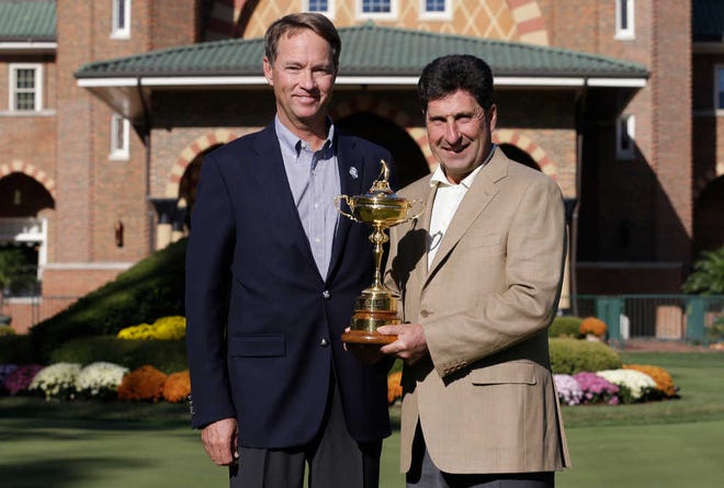 USA captain Davis Love III, left, and European captain Jose Maria Olazabal pose with the trophy at the Ryder Cup PGA golf tournament Monday, Sept. 24, 2012, at the Medinah Country Club in Medinah, Ill. (AP Photo/David J. Phillip)